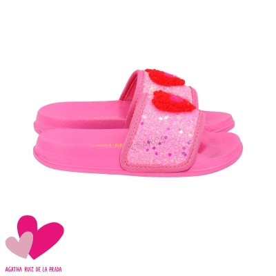 Chinelos cor-de-rosa com pompons vermelhos na tira superior