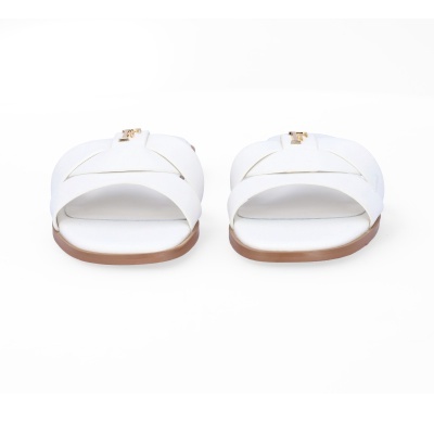 Sandálias brancas cruzadas com sola castanha e placa dourada