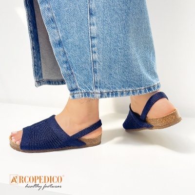 Sandálias azuis tricotadas com sola castanha e calças de ganga azuis