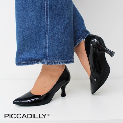 Sapatos de salto médio em verniz preto brilhante com calças de ganga azul