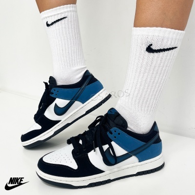 Tênis Nike branco, azul e preto com meias Nike brancas em fundo branco