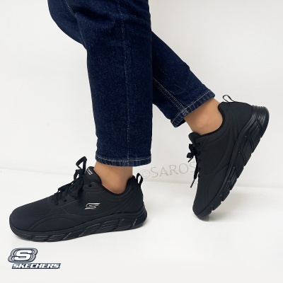 Ténis Skechers pretos em uso com calças de ganga azul