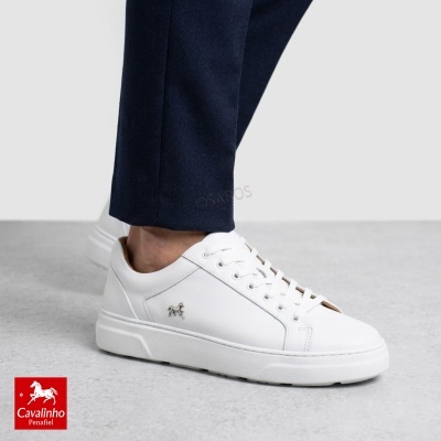 Ténis brancos em pele com detalhe metálico de cavalo e sola branca.