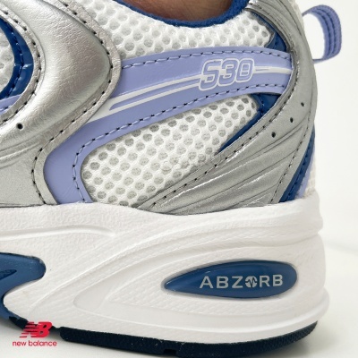Sapatilha New Balance branca, azul, lilás e cinza com malha e detalhes em pele sintética
