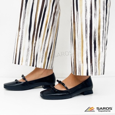 Sapatos pretos de verniz com salto baixo e calças de riscas verticais