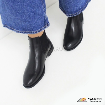 Botas pretas de cano curto em pele com elástico lateral em fundo branco