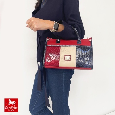 Mala Cavalinho tricolor com padrão em relevo, ouro detalhes, pega pequena, contra fundo branco.