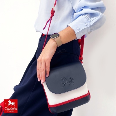 Mala de mão azul, branca e vermelha com relevo de cavalo e alça vermelha