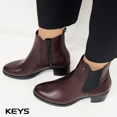 Botins de pele castanha com elástico e fecho de correr, salto baixo preto.