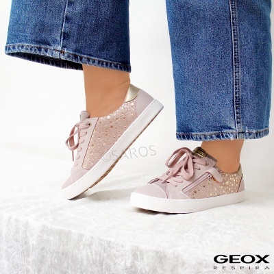 Ténis rosa claro com detalhes brilhantes e sola branca usados com calças de ganga