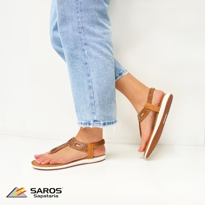 Sandálias castanhas de tecido trançado com sola branca usadas com jeans azuis claras