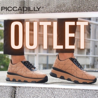 Sapatos tipo sapatilhas bege com padrão de linhas pretas e sola preta espessa usados com calças pretas