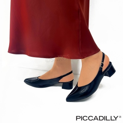 Sapatilhas pretas de bico fino com tira e salto baixo junto a vestido vermelho.