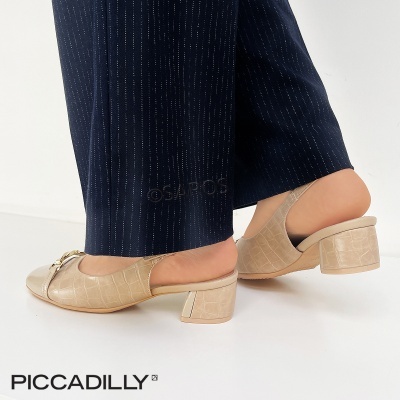 Sapatos bege de salto médio com textura crocodilo e detalhe dourado, usados com calças azul-escuras risca de giz