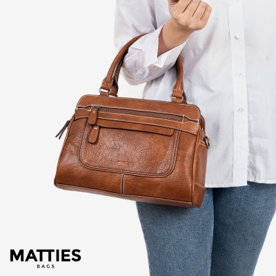 Mala de mão castanha em pele com bolso frontal e alças sendo segurada