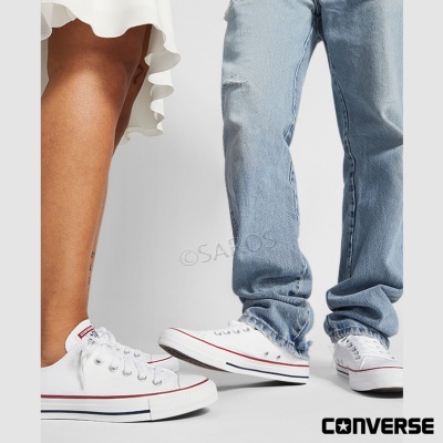 Pessoas usando ténis brancos Converse com detalhes em vermelho e azul
