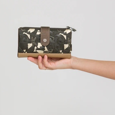 Carteira de senhora preta e castanha em pele sintética com padrão geométrico a ser segurada numa mão