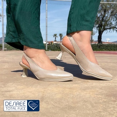 Sapatos de salto alto slingback bege metálico com calças verdes em piso exterior