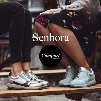 Dois pares de sapatilhas femininas, um prateado com castanho e outro azul claro, usadas por duas mulheres sentadas.