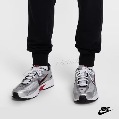 Sapatilhas desportivas Nike cinza prateado e vermelho, usadas com calças pretas