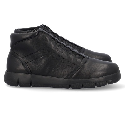 Sapatilhas pretas tipo botins em couro com sola preta e nome Camper gravado na lateral.