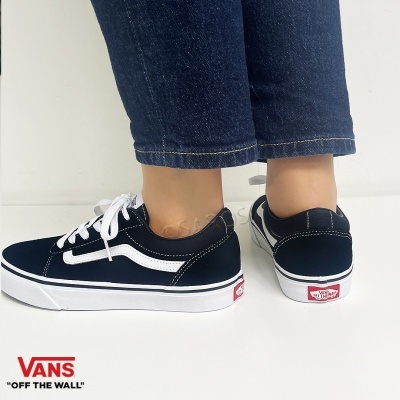 Sapatilhas Vans pretas com cadarços brancos e sola branca em fundo branco