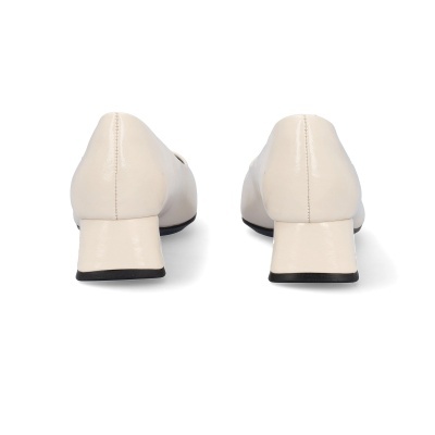 Par de sapatos femininos bege claro com salto baixo em fundo branco