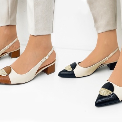 Dois pares de sapatos de mulher com salto baixo quadrado, um castanho e creme, outro preto e creme, com fivela dourada no bico.