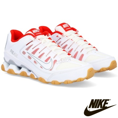Sapatilhas Nike brancas com detalhes vermelhos e sola castanha em fundo branco.