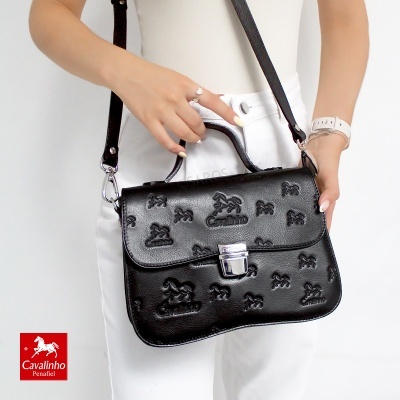 Mala de senhora preta em pele com padrões em relevo e fecho metálico.