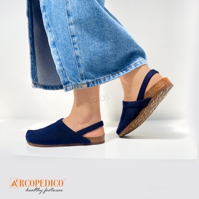 Sapatilhas azuis com sola castanha e calças de ganga azuis