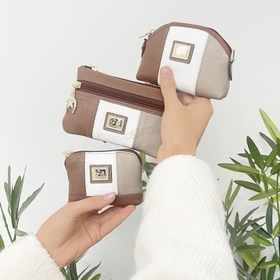 Três bolsas pequenas castanho, bege e branco com detalhes metálicos e logo em relevo