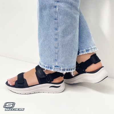 Sandálias pretas Skechers com sola branca e calças de ganga azul claro