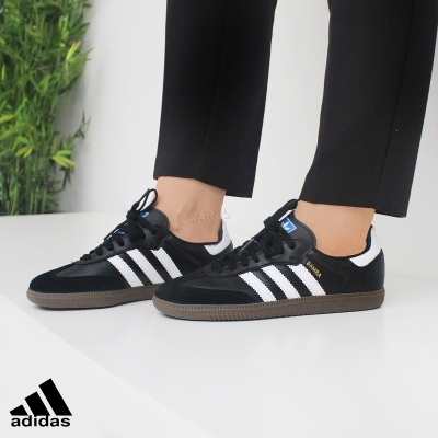 Ténis Adidas clássicos pretos com riscas brancas e sola castanha clara