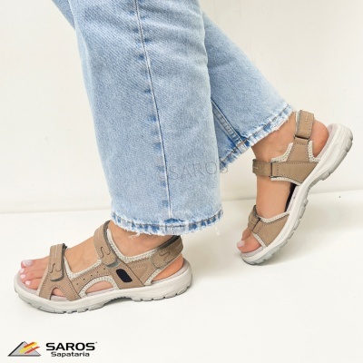 Sandálias bege de senhora com tiras ajustáveis usadas com jeans claros.