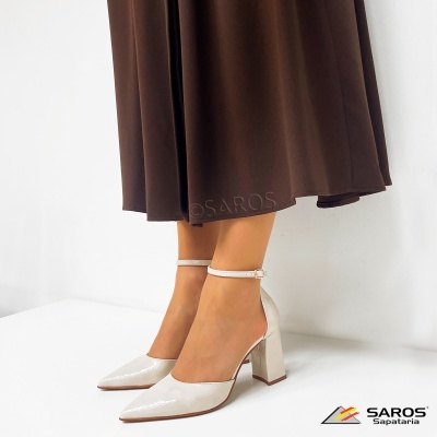 Sapatos de salto alto brancos com tira no tornozelo e saia castanha em fundo branco