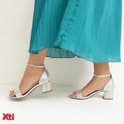 Sandálias prateadas com salto quadrado usadas com saia azul