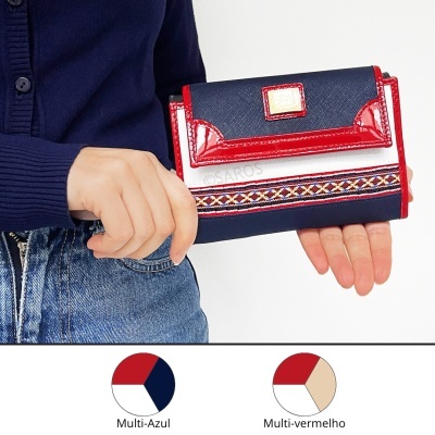 Carteira feminina azul escuro com detalhes vermelhos e padrão geométrico segurada por pessoa