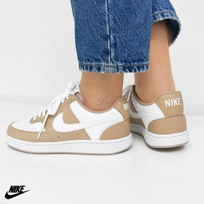 Sapatilhas Nike brancas e bege com sola branca e logo Nike no calcanhar.