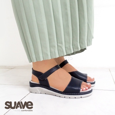 Sandálias pretas com sola branca usadas com saia verde plissada