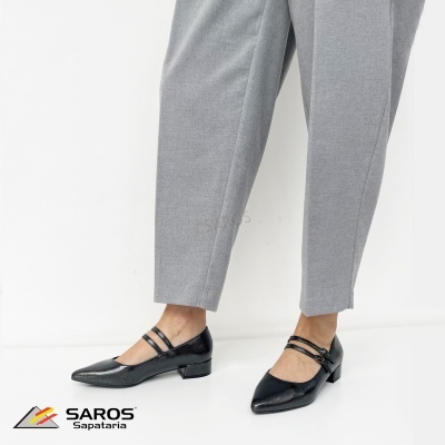 Sapatos pretos de senhora com tiras usadas com calças cinzentas