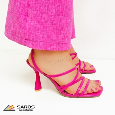 Sandálias rosa choque de salto alto com tiras finas usadas com calças rosa choque