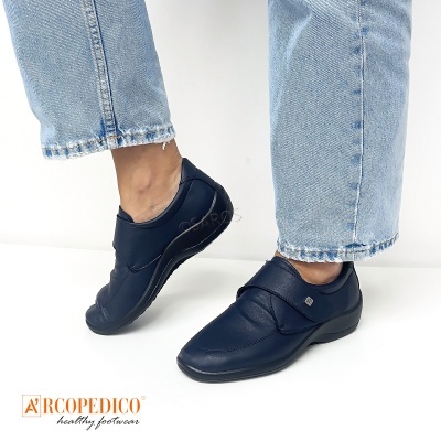 Sapatos femininos escuros com sola preta e fecho em tira sobre o peito do pé