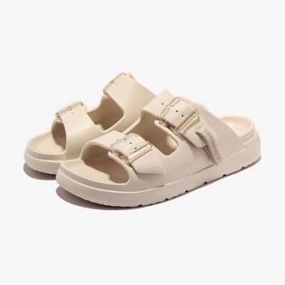 Sandálias creme sintéticas com duas tiras largas e fivelas ajustáveis.