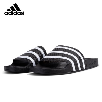 Chinelos Adidas pretos com riscas brancas em fundo branco