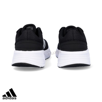 Sapatilhas Adidas pretas com sola branca vistas de trás