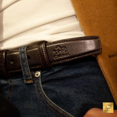 Cinto de pele castanha escura com logo gravado e jeans azul