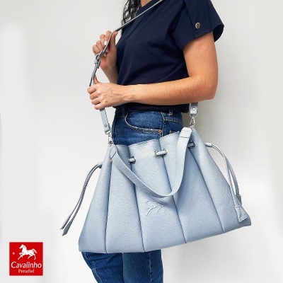 Mala de ombro grande azul clara em pele com alças ajustáveis e relevo de cavalo
