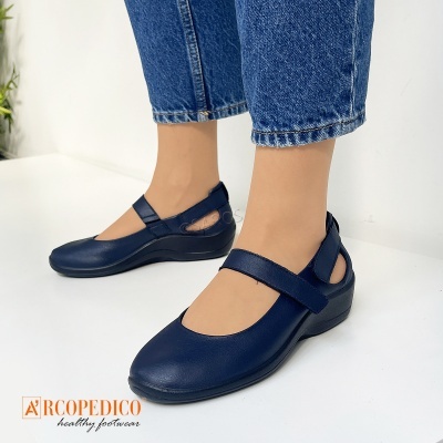 Sapatos femininos azul escuro com fecho de velcro usados com calças de ganga