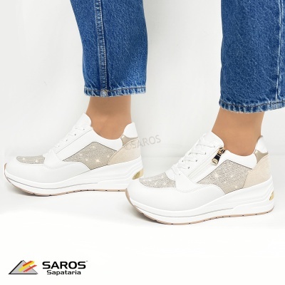 Ténis brancos e bege com detalhes prateados e fecho com atacadores e zíper, usados com jeans azuis